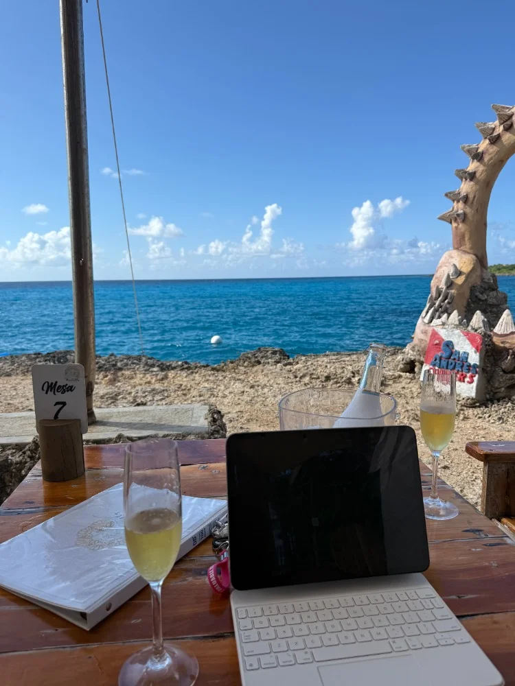 Ambiente de trabalho — laptop em uma mesa à beira-mar